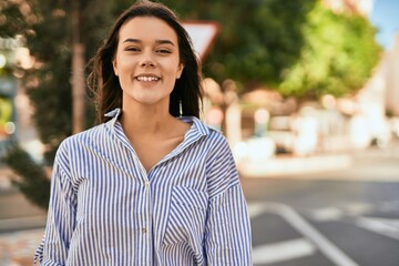 Young hispanic girl smiling happy standing at the city.