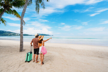 Young couple traveler with luggage relaxing and enjoying at beautiful tropical sand beach, Summer...
