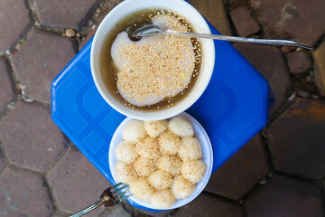 Vietnamese glutinous rice balls (Banh troi) on a bowl on street, with sesame seeds and banh chay in...