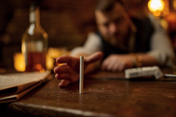 Fototapeta na wymiar Drunk man tries to take a cigarette