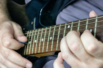 Obraz na płótnie Canvas Close-up of man playing lead guitar solo