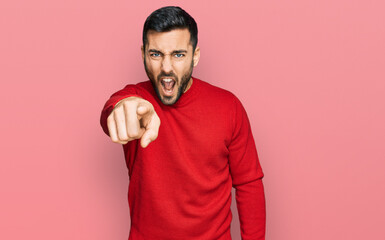 Young hispanic man wearing casual clothes pointing displeased and frustrated to the camera, angry...