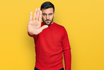 Young hispanic man wearing casual clothes doing stop sing with palm of the hand. warning expression...