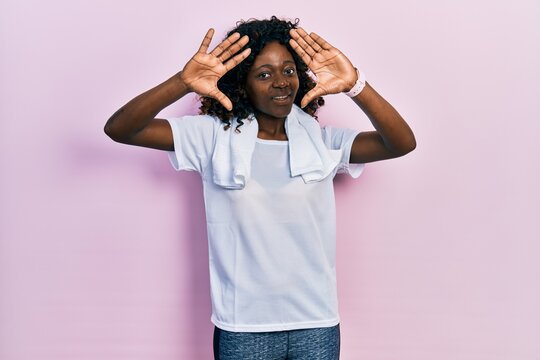 Young african american woman wearing sportswear and towel doing frame using hands palms and fingers, camera perspective