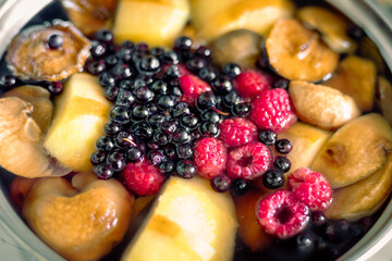 Casserole with fruits and berries. Cooking fruit and berry compote. Pear, apple, raspberry and black currant compote
