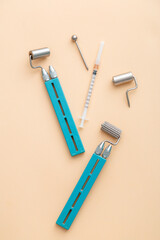 Cosmetology dermaroller dermatology tools, mesoscooter for hardware cosmetology, syringe for youth health injections in face body. Cosmetologists Skincare Treatment tools flat lay on beige background