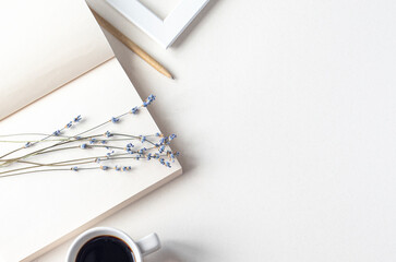 Flat lay as still life with minimal composition. Opened notebook on beige desk, dried lavender and...