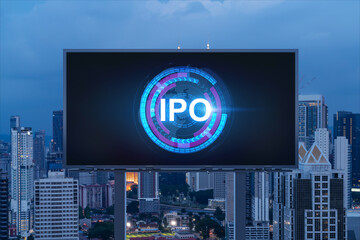 IPO icon hologram on road billboard over night panorama city view of Kuala Lumpur. KL is the hub of initial public offering in Malaysia, Asia. The concept of exceeding business opportunities.