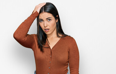 Young hispanic woman wearing casual clothes surprised with hand on head for mistake, remember...