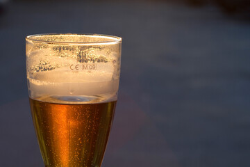 Half empty or half full glass of beer or lager. Pessimistic. Optimistic.