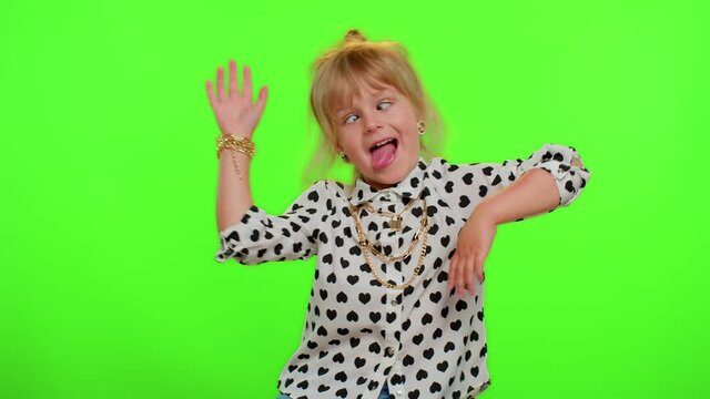 Funny teen child kid girl making playful silly facial expressions and grimacing, fooling around, showing tongue. Posing isolated on chroma key green background. Childhood lifestyle. Young children