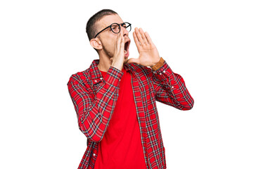 Hispanic young man wearing casual clothes shouting angry out loud with hands over mouth