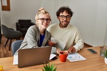 Two hispanic business workers smiling happy working at the office.