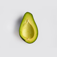 Half a pitted green ripe avocado isolated on light-gray background