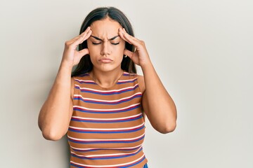 Young brunette woman wearing casual clothes with hand on head, headache because stress. suffering migraine.