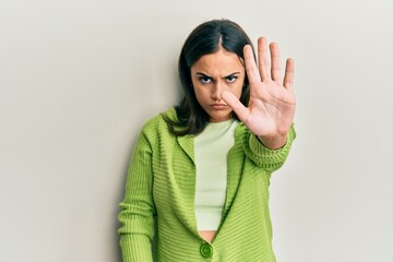 Young brunette woman wearing casual clothes doing stop sing with palm of the hand. warning...