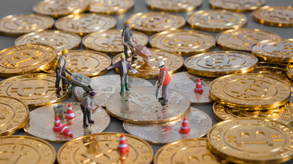 cryptocurrency concept with bitcoin symbol and Miniature human on Golden coins