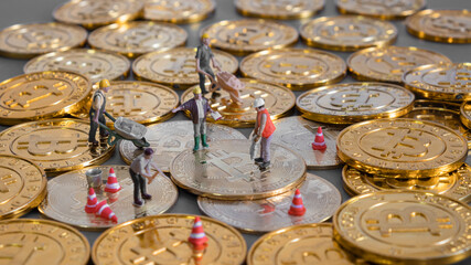 cryptocurrency concept with bitcoin symbol and Miniature human on Golden coins