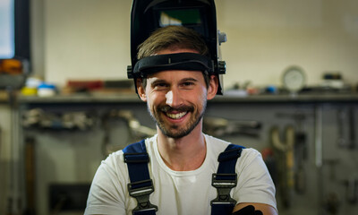 Close-up of the young welder with the welding mask. - obrazy, fototapety, plakaty