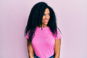 Middle age african american woman wearing casual clothes smiling looking to the side and staring away thinking.