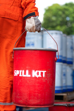 A rescue team is holding red box of "Spill kit", ready to response on chemical spilling accident. Industrial emergency scene photo. Close-up and selective focus.