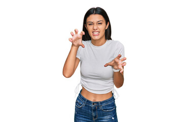 Young hispanic girl wearing casual white t shirt smiling funny doing claw gesture as cat,...