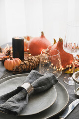 Halloween and Thanksgiving day dinner decorated fallen leaves, pumpkins, spices, grey plate. Close up. Vertical format.