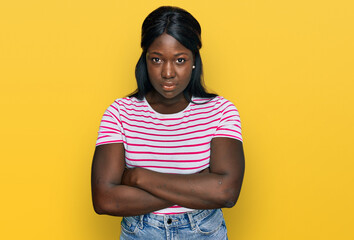 African young woman wearing casual striped t shirt skeptic and nervous, disapproving expression on...