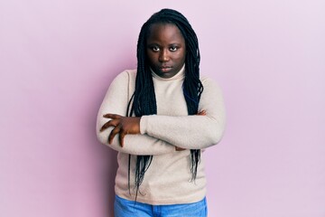 Young black woman with braids wearing casual winter sweater skeptic and nervous, disapproving...