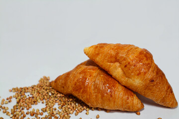 croissants fresh baked, crispy, delicious and whole grain buckwheat on white background, copy space by close up view.