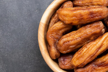 Close up of sun dried bananas in the bowl on black background, Thai dessert