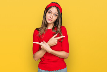 Young brunette woman wearing casual clothes pointing to both sides with fingers, different direction disagree