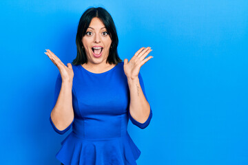 Fototapeta premium Young hispanic woman wearing casual clothes celebrating crazy and amazed for success with arms raised and open eyes screaming excited. winner concept