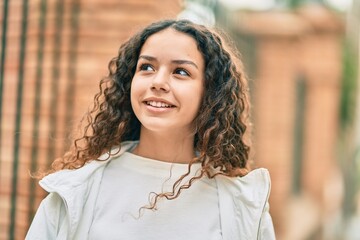 Hispanic teenager girl smiling happy standing at the city.