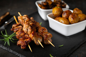 Fried meat on a skewer with baked potatoes and mushrooms
