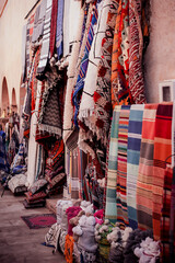 Fototapeta na wymiar sale of traditional bright colored textiles and fabrics on the street market in the old town in the Middle East of Morocco