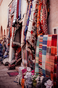 sale of traditional bright colored textiles and fabrics on the street market in the old town in the Middle East of Morocco