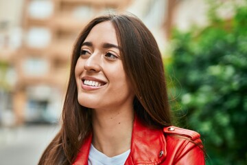 Young hispanic woman smiling happy standing at the city.