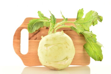 One uncooked organic kohlrabi cabbage with cutting wooden board, close-up, isolated on white.