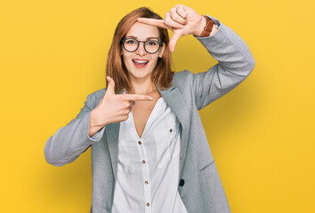 Young caucasian woman wearing business style and glasses smiling making frame with hands and fingers with happy face. creativity and photography concept.