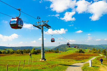 A cabin cable car travels up a green mountain - Willingen, Sauerland