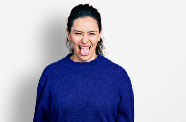 Fototapeta premium Young hispanic woman wearing casual clothes sticking tongue out happy with funny expression. emotion concept.