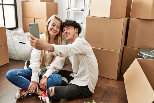 Young beautiful couple smiling happy make selfie by the smartphone at new home.