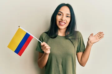 Foto op Canvas Young hispanic girl holding colombia flag celebrating achievement with happy smile and winner expression with raised hand © Krakenimages.com