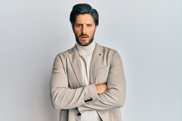 Obraz premium Young hispanic man with arms crossed gesture in shock face, looking skeptical and sarcastic, surprised with open mouth