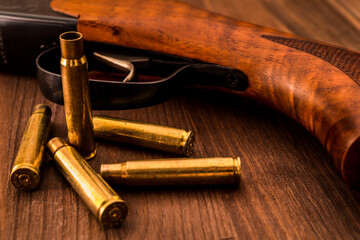 Fototapeta premium Rifle with empty shells lie on a wooden table
