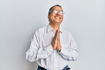 Middle age indian man wearing casual clothes and glasses begging and praying with hands together with hope expression on face very emotional and worried. begging.