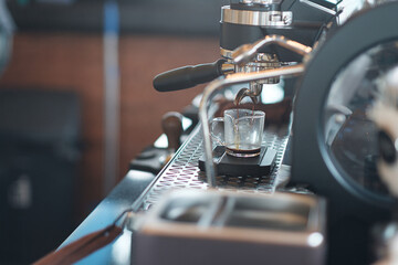 The coffee that is flowing into the cup from the espresso machine.