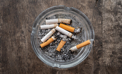 cigarettes butts in ashtray on wood background