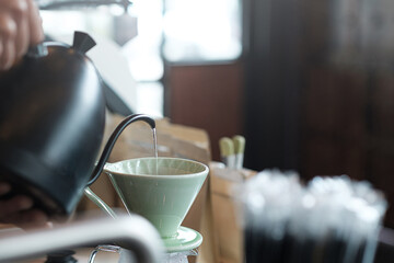 The water in the kettle is flowing into the drip filter.